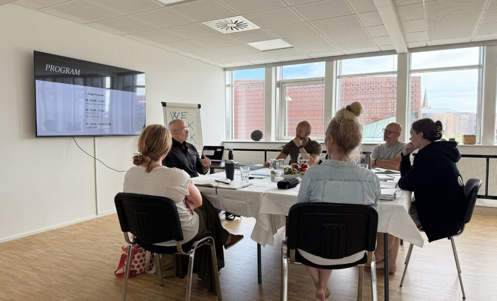 Workshop med deltagere ved bordet i salen hos Torben Rif Academy